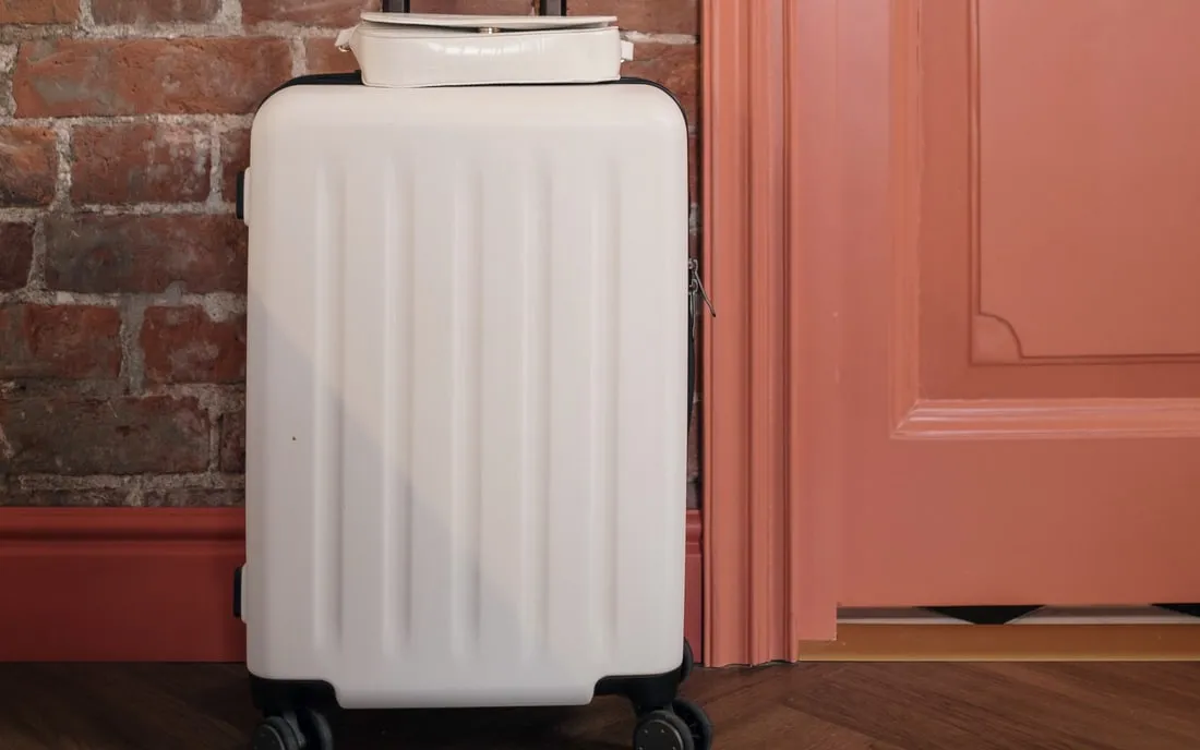A packed cabin suitcase standing by a front door